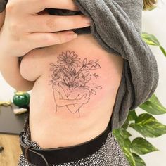 a woman with a flower tattoo on her stomach