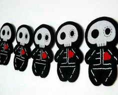 a row of black and white skulls with red hearts on their backs are lined up against a white wall