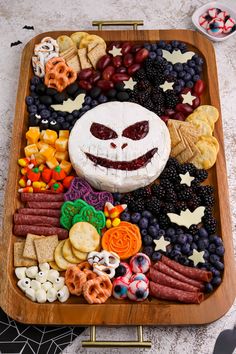 a platter filled with fruit, crackers and snacks