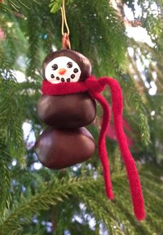 an ornament hanging from a christmas tree with a snowman on it's head