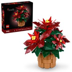 a lego plant with red flowers and green leaves in a wooden pot next to the box