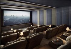 an empty movie theater with two seats facing the screen and a table in front of it