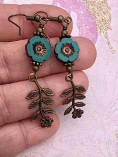 Flowers, flowers, and more flowers! The beautiful teal flowers are Czech glass beads. I paired them with high quality Vintaj charms, which are solid brass and American made using an eco friendly process. The effect of combining natural brass and Czech glass beads is so pretty to me. I love the elegant, vintage look it creates. The hooks on these earrings are antique brass and are nickel free. All of my earrings come on a hand stamped earring card and are lovingly wrapped in colorful tissue and p Vintage Flower Charm Dangle Earrings, Nickel-free Bohemian Flower Earrings, Vintage Turquoise Flower Earrings, Bohemian Green Flower Charm Earrings, Nickel-free Czech Glass Flower Earrings, Turquoise Flower-shaped Earrings With Flower Charm, Bohemian Flower Charm Drop Earrings, Green Czech Glass Flower Earrings, Bohemian Drop Earrings With Handmade Flowers