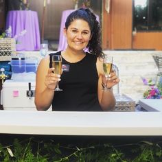 a woman holding two wine glasses in her hands