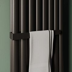 a towel hanging on the side of a radiator next to a green wall