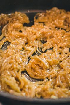 some food is cooking in a frying pan on the stove top, and it appears to be fried