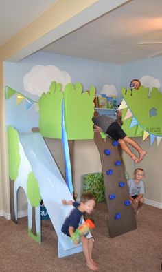 two children playing on a slide in a playroom