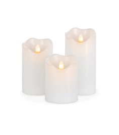 three white candles sitting next to each other