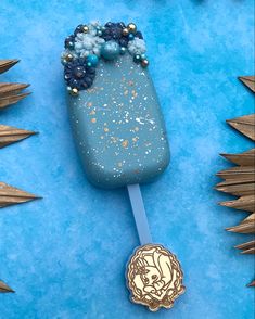 a blue and gold popsicle sitting on top of a blue table next to other decorations