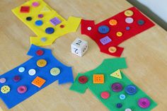 four different colored pieces of felt sitting on top of a wooden table with numbers and shapes