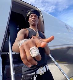 a man in black shirt pointing to the side of an airplane with his hand out