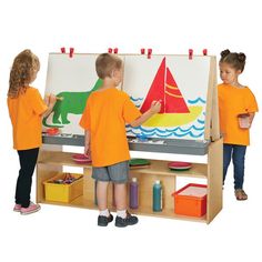 two young children are playing with an easel