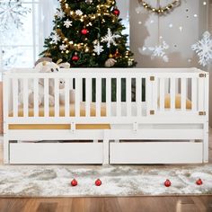 a white crib in front of a christmas tree