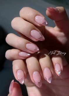 a woman's hand with some pink and white nail polishes on her nails