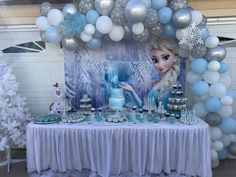 a frozen princess themed birthday party with balloons and desserts on a table in front of a backdrop