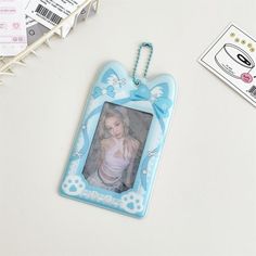 a photo frame hanging on a key chain next to some paper tags and other items