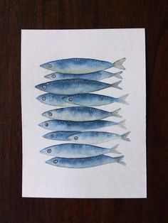 five blue fish lined up on top of each other in the middle of a piece of paper