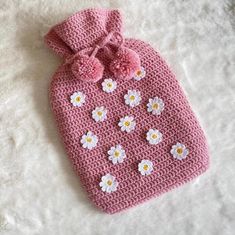 a pink crocheted bag with white flowers on it