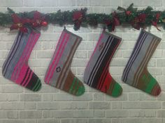 three christmas stockings hanging on a brick wall