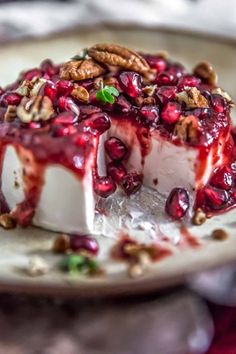 a piece of cheesecake covered in pomegranate and nuts