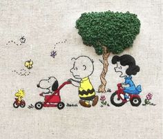 a cross stitched picture of peanuts riding a tricycle with snoop and charlie on it