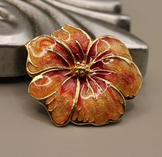 Beautiful vintage hibiscus flower brooch. Enameled flower pin in red-orange color. Size 1.5 x 1.5 inches. Excellent vintage condition. Luxury Orange Brooches For Gifts, Gold Flower Enamel Pin For Gift, Gold Flower Enamel Pin Gift, Collectible Gold Flower Enamel Pin, Luxury Elegant Orange Brooches, Vintage Red Flower Shaped Jewelry, Vintage Gold Flower Brooch, Unique Orange Flower-shaped Jewelry, Orange Flower-shaped Adjustable Earrings