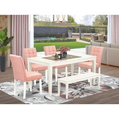 a white table with pink chairs in a living room