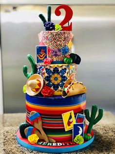 a multi - tiered birthday cake decorated with colorful decorations and numbers on it's sides