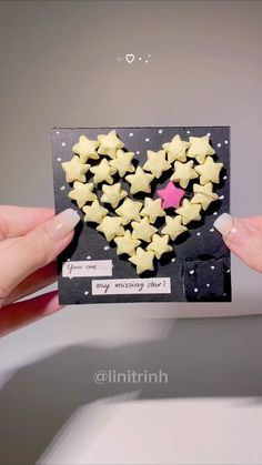 someone holding up a card with stars in the shape of a heart