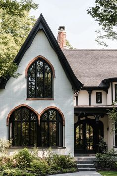 a white house with black trim and arched windows