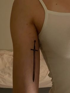 a woman with a cross tattoo on her arm, holding a knife in the other hand