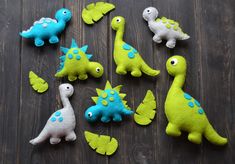 the toy dinosaurs are all different colors and sizes, but one is green with blue spots