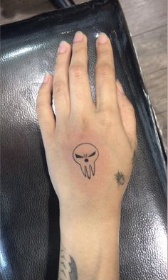 a person's hand with a tattoo on it and an alien head in the middle