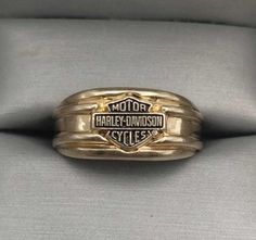 a gold harley davidson ring sitting on top of a cushion