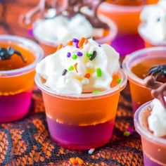 halloween desserts in plastic cups with sprinkles and candy on the top