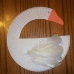 a paper plate with a white swan on it and an orange beak in the shape of a circle