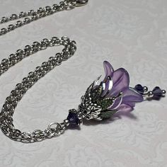 VIOLET SILVER FLOWER PENDANT  ▪️▪️▪️▪️▪️▪️▪️️▪️▪️▪️▪️▪️▪️ This pretty vintage inspired violet purple pendant is made with a super cute Lucite fairy flower which has been hand painted with an iridescent finish. It has Swarovski crystals in beautiful deep purple added for sparkle when it moves and is finished with ornate floral bead caps and either 16'' or 18'' chain that can be chosen from the drop down menu. Beautifully light weight, perfect for special occasions, festivals and bridesmaids yet c Luxury Purple Flower Pendant Jewelry, Luxury Purple Flower Pendant Necklace, Violet Pendant Necklace, Fairy Jewelry Purple, Purple Flower Accessories, Affordable Purple Flower-shaped Jewelry, Fairycore Necklace Purple, Purple Cross Necklace, Dark Purple Jewelry