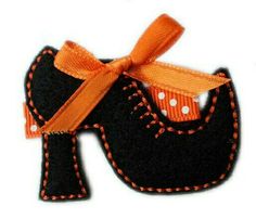 an orange ribbon is tied to a small black horse ornament with white polka dots