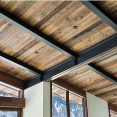 the inside of a house with wooden ceilings and windows