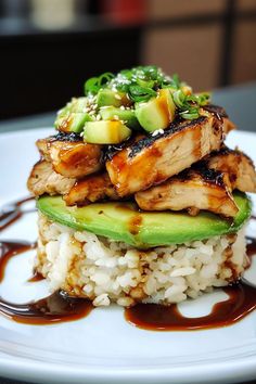 a white plate topped with rice and meat covered in sauce