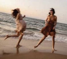 two women running on the beach at sunset