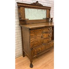 an old dresser with a mirror on it's top and wooden drawers in the bottom