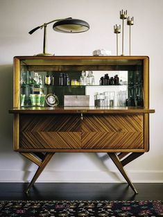 a wooden cabinet sitting on top of a floor next to a wall with pictures and lights