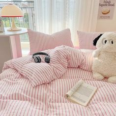 a stuffed dog sitting on top of a bed covered in pink and white striped sheets