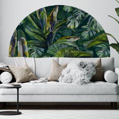 a living room with a white couch and large wall mural