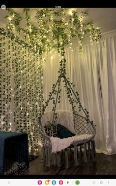 a room with white curtains and lights hanging from the ceiling is decorated with green vines