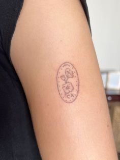 a woman's arm with a small clock tattoo on the left side of her arm