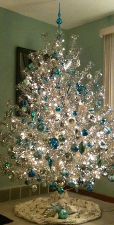 a white christmas tree with blue and green ornaments