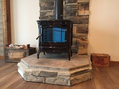 a wood burning stove sitting on top of a stone platform