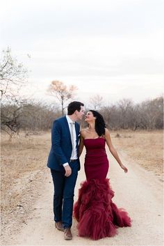 a man and woman in formal wear walking down a dirt road with color swatches